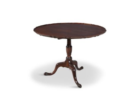 A GEORGIAN MAHOGANY PIE CRUST TILT TOP SUPPER TABLEwith raised on centre pillar, on carved tripod legs and pad feet. 94 cm di