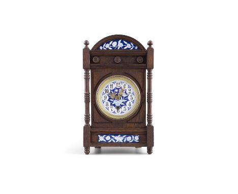 AN ARTS &amp; CRAFTS STAINED OAK CASED MANTLE CLOCK, in the manner of Lewis F Day, the arch top with inset blue and white ena