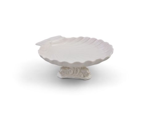 A FIRST PERIOD BELLEEK SERVING DISH, the shell dish covered in cream glaze, raised on fish supports. 24cm diameter, 10cm high