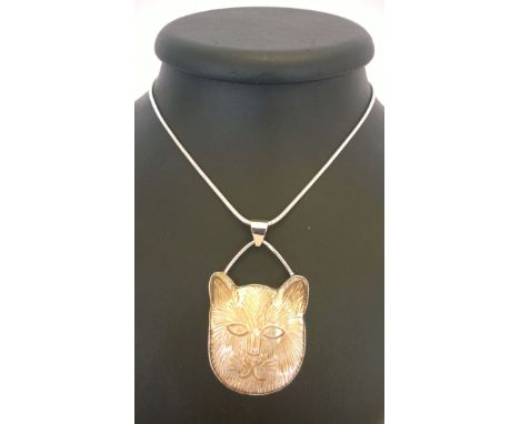 A cat face pendant carved in pearl shell set in 925 silver on a rope chain