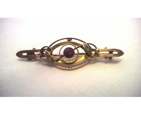 An antique gold bar brooch set with a central ruby and tiny seed pearls. Art Nouveau design measuring 5cm across. No hallmark