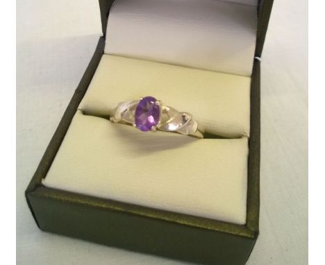 Silver ladies ring set with an oval amethyst on cross-over shoulders. Size U.