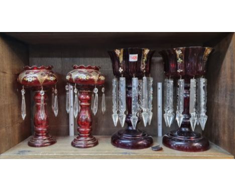 A pair of cranberry stained glass lustres, 28.5cm high; together with another pair of ruby glass examples, 33.5cm high. (one 