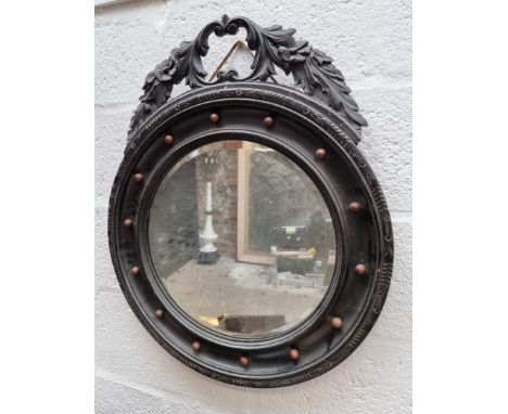 An antique ebonized circular wall mirror, 59cm diameter.&nbsp; 
