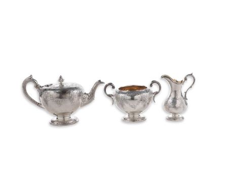 A Victorian Scottish silver three-piece tea set with chased circular bodies, chased circular pedestal bases and scroll handle