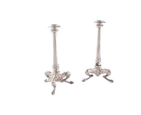 A pair of late Victorian silver tapersticks, with tapering reeded columns, the bases formed by three conjoined, radiating leg