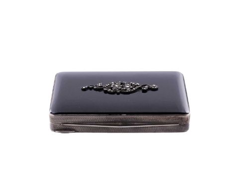 A continental silver art deco compact with engine turned decoration and a black hardstone cover set with a marcasite floral s