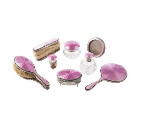 A George V ten-piece silver dressing table set, decorated in translucent pink enamel over a guilloche ground to include: two 