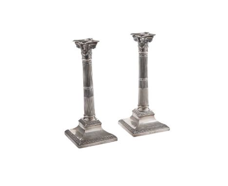 A pair of Victorian silver candlesticks, on bevelled square bases with borders of scales, fluted columns and detachable nozzl