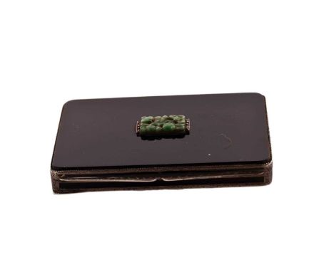 An art deco silver and black enamel cigarette case with an engine-turned base, the resin cover set with a carved jadeite and 