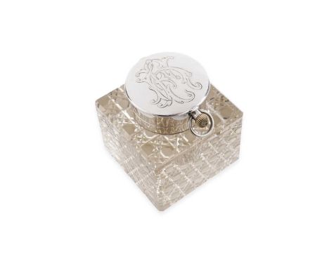 An Edwardian silver mounted clear glass inkwell, cuboid in form with bevelled edges and a cut pattern on the base, the hinged