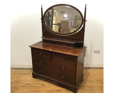 An Edwardian mahogany and satinwood banded dressing chest, the raised superstructure with oval shaped mirror and two drawers,