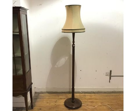 A mid 20thc oak floor lamp, the turned stem with fluted and baluster shaped details, raised on a circular base (height to fit