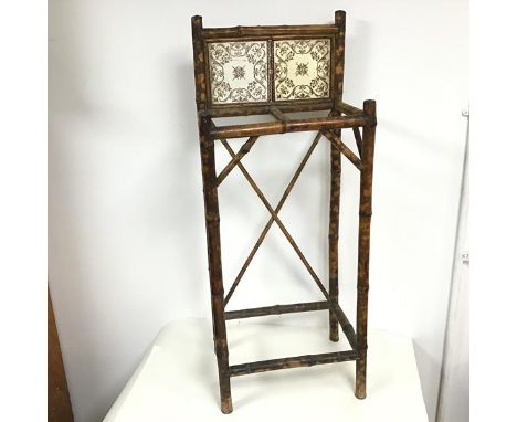 An early 20thc bamboo stick stand with gallery back inset with ceramic tiles, with an X stretcher to back and square stretche