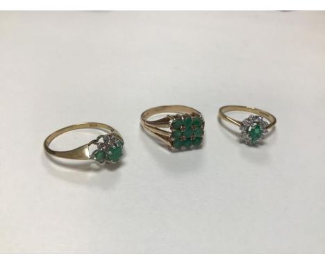 A 9ct gold oval emerald and diamond cluster set ring set ten diamonds (N), a 9ct gold three stone emerald and diamond cluster