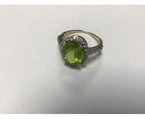 A 9ct gold peridot ring with paste set border and shoulders (one stone missing) (L)