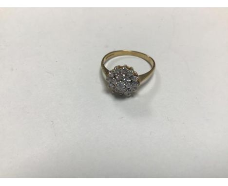 A 9ct gold diamond cluster ring with a central stone surrounded by six diamonds and an outer surround of twelve diamonds (L) 