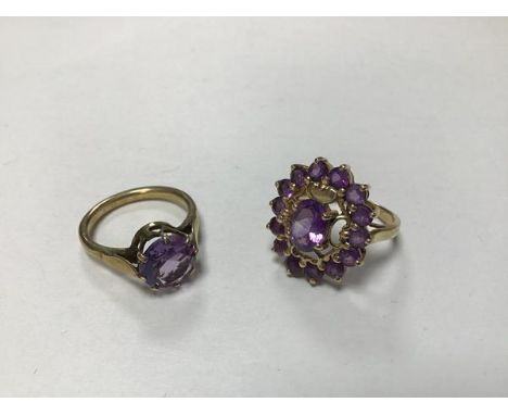 A yellow metal dress ring mounted circular amethyst in claw setting (N/M), and a 9ct gold amethyst cluster ring mounted in cl