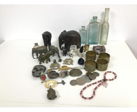 A mixed lot comprising carved elephants, two elephant badges for the 19th Alexandra Hussars, four brass napkin rings with fig