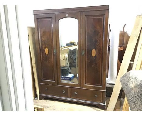 An Edwardian mahogany and inlaid mirror door wardrobe with a pair of panel cupboard doors, enclosing hanging space, flanking 