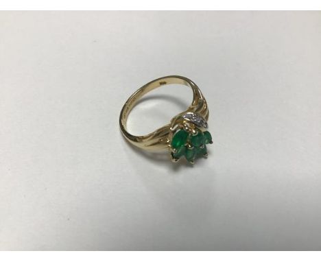 A 9ct gold emerald and diamond set cluster ring with six marquise cut emeralds and three brilliant cut diamond chips (M/N) (3