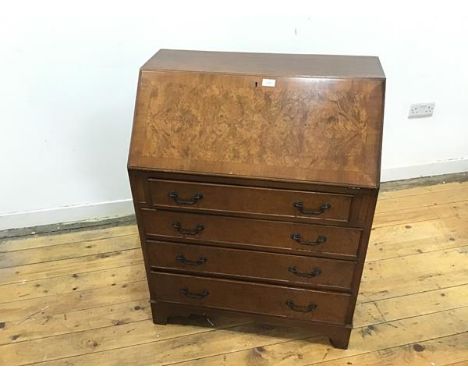 A George II style walnut fall front bureau, c.mid 20thc., the rectangular crossbanded top enclosing a fitted interior, above 