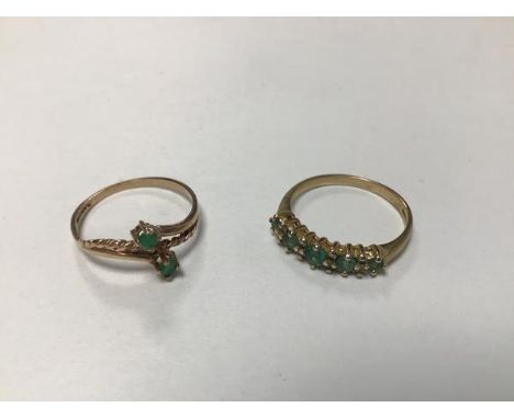 A 9ct gold five stone graduated emerald and diamond chip ring (M) and a 9ct gold crossover ring set two emeralds (N) (2.78g) 