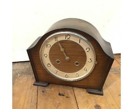 A 1930s/40s oak cased Art Deco style mantel clock with arched top over a circular dial, with arabic numerals, on bracket feet