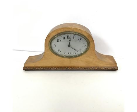 A mid 20thc French mantel clock, the metal dial with arabic numerals within a beech frame with a carved base on bun feet (17c