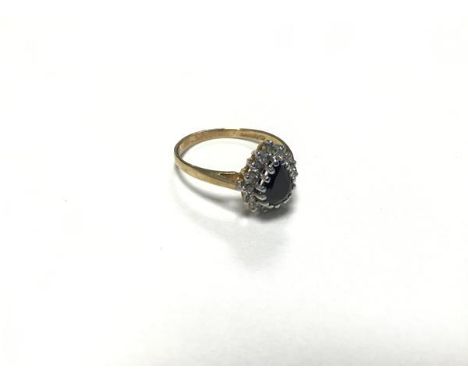 A sapphire and diamond cluster ring, the pear shaped sapphire enclosed within a surround of thirteen brilliant cut diamond ch