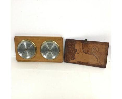 A modern wall mounted barometer and thermometer on wooden frame and a pokerwork panel formerly a hinged box lid with sphinx t