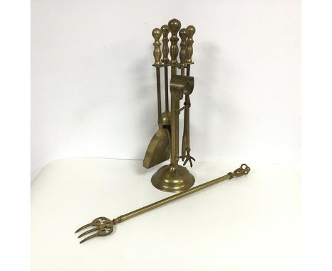 A set of brass fire tools on stand including tongs, shovel, poker and brush also a brass toasting fork with urn finial and cl