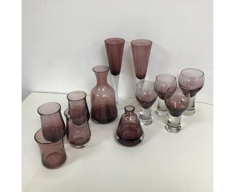 A selection of amethyst coloured glass including a carafe of bell form, four similar tulip shaped vases, two champagne flutes