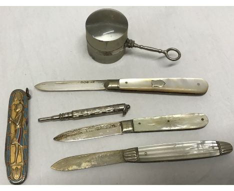 Three silver mother of pearl fruit knives, propelling pencil, Egyptian motif fruit knife and magnifying glass with chip to gl