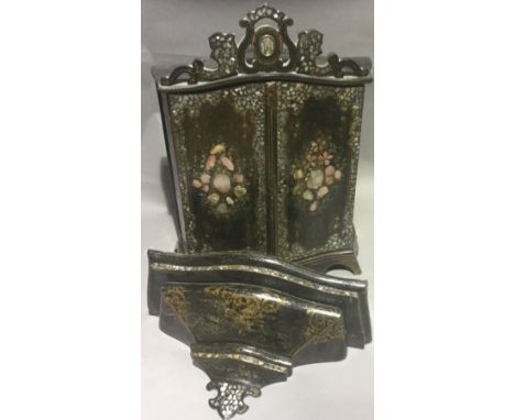 A small Victorian mother-of-pearl inlaid ebonised cabinet, the pierced scrolling top above the twin serpentine doors enclosin