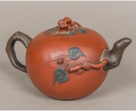 A Chinese Yixing teapot, of ovoid form, with scrolling branch decorations, the underside with seal mark, the lid marked to th