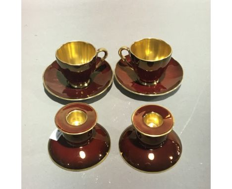 A pair of Carlton Ware Rouge Royale candlesticks, two cups and saucers