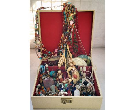 A vintage jewellery box containing various necklaces including a carved alabaster necklace with an albaster pendant in the fo