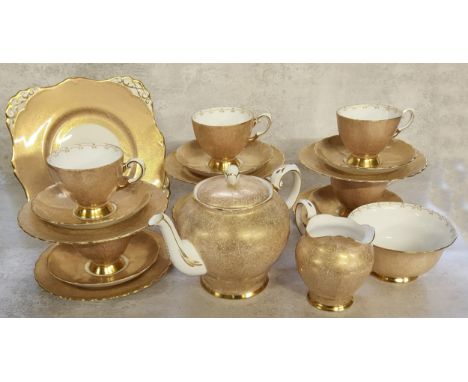 An Art Deco Tuscan tea service for six, decorated with an intricate gold filigree pattern on a white ground, gilded, comprisi