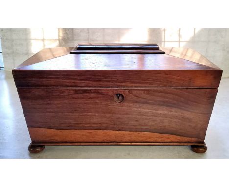 A William IV rosewood tea caddy, of sarcophagus form, the hinged cover enclosing a pair of lidded compartments and a central 