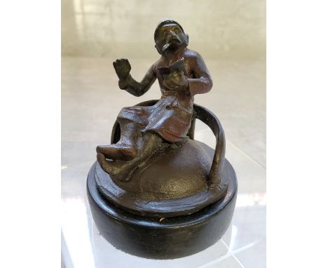 A novelty cold painted bronze paperweight of a seated anthropomorphic monkey in a smoking jacket &amp; cap, smoking a cigar w