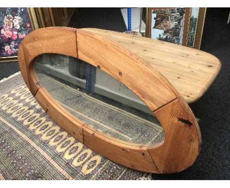 An oval pine coffee table and mirror 