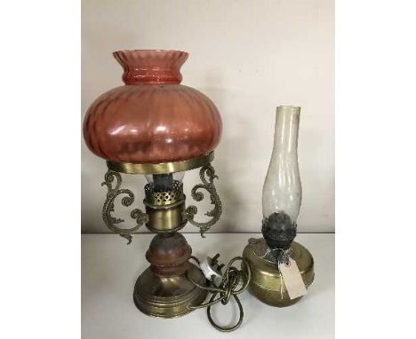 A brass oil lamp, converted glass lamp with ruby glass shade 