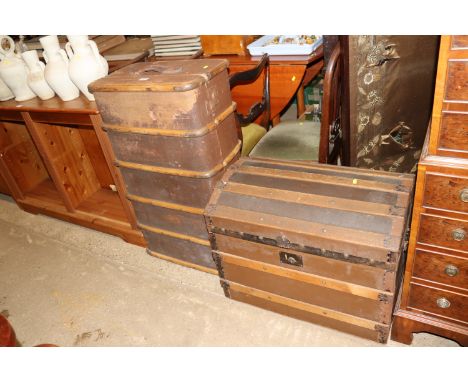 A vintage wooden and metal bound travelling trunk and a wooden and canvas dome topped trunk