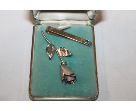 A 9ct gold tie clip set aqua marine stone, approx.. total weight 5.5gms; and a Sterling silver brooch in the form of a rose 