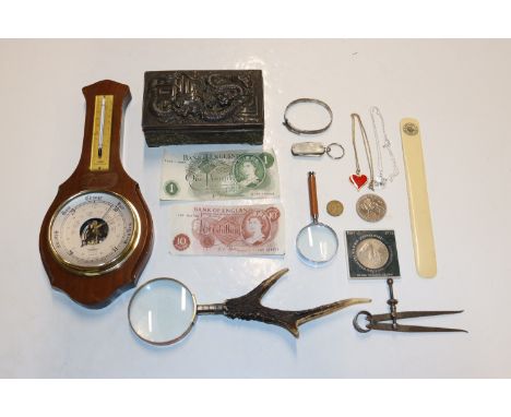 A box containing a barometer, trinket box, magnifying glasses, coins and bank notes 