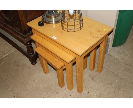 A nest of three light oak coffee tables 