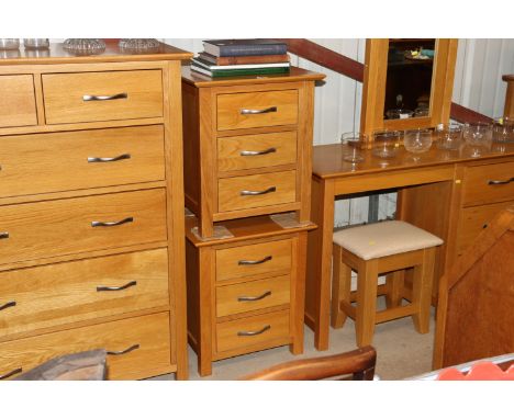 A pair of light oak three drawer bedside chests