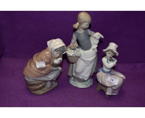 A Lladro figurine, Girl with Lamb 4835 and two Nao figurines, Girl with Duck in Basket and Girl with Puppy .