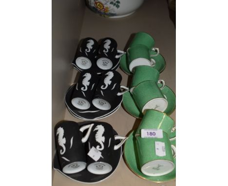 An assortment of coffee cups and saucers including green by Bishop and matte black with sea horse design by Thistledown.